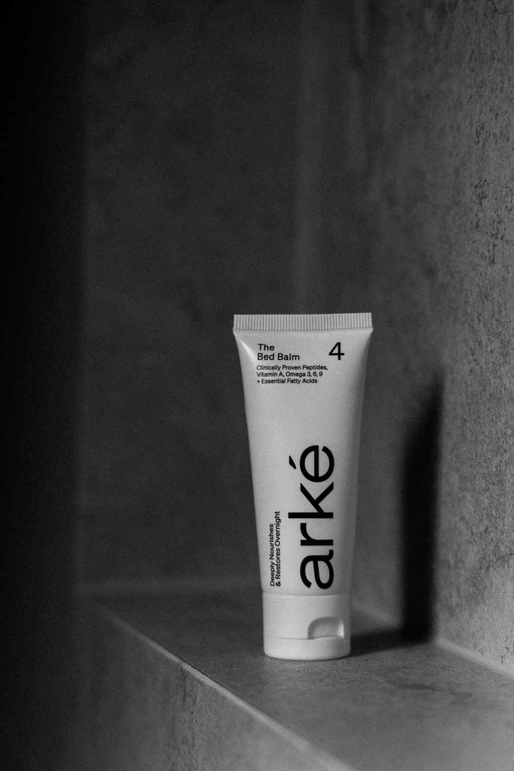 Arke bed balm product on a dark background