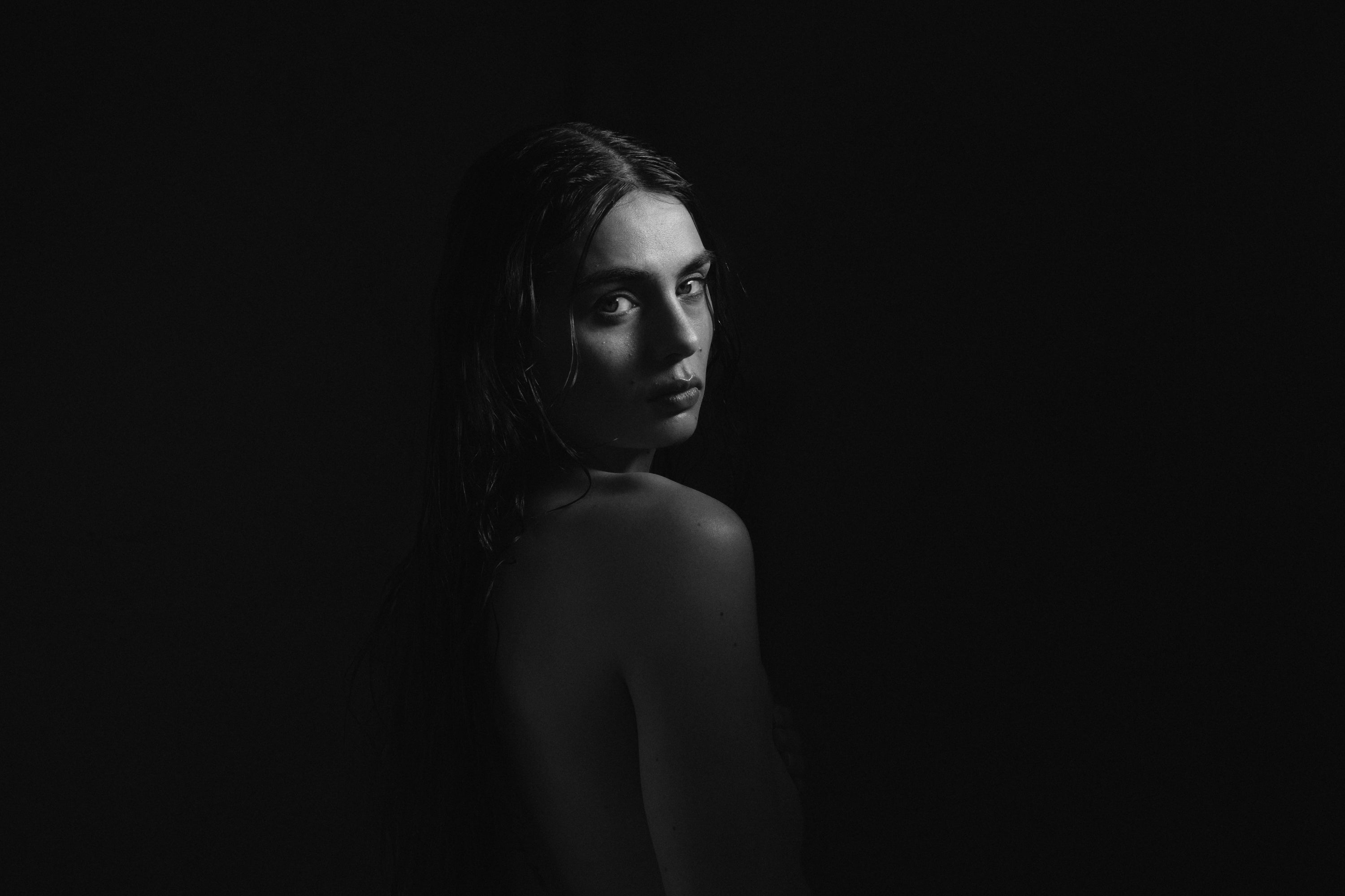 Woman standing in a dark room with minimal lighting